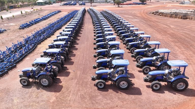 Rangées de tracteurs bleus neufs alignés sur un parc