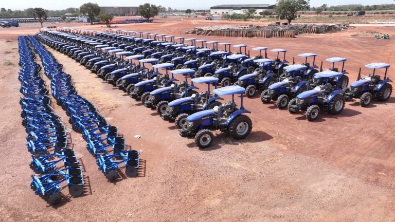 Parc de tracteurs du groupe près de Bobo-Dioulasso : rangées de tracteurs bleus en diagonale, vue aérienne de janvier 2026